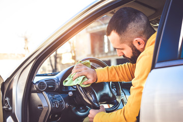 Cleaning with green microfiber cloth polishing car, interior concept