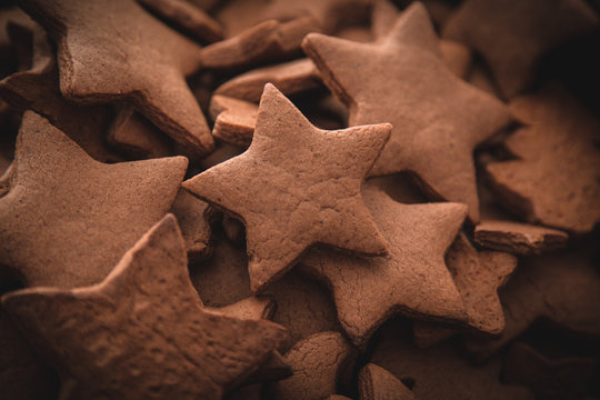 Christmas gingerbread cakes in shape of stars on rustic wooden table.