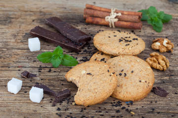 Oat cookies with chocolate and cinnamon on wooden board, close up.

