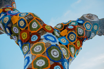 Fototapeta premium Tree with storm yarn. Sewn with coloured wool, street and creative art