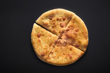 Traditional Khachapuri on black stone background
