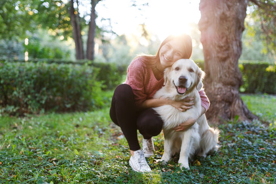 Photo of woman hugging dog on lawn