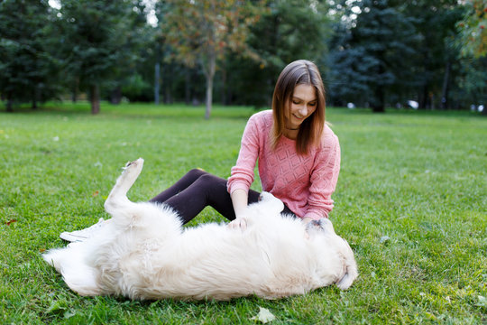 Photo of brunette and retriever lying on lawn