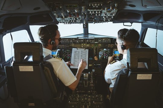 Pilot and copilot discussing over clipboard