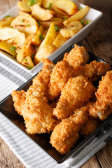 Fried chicken wings in breading and potato close-up. vertical
