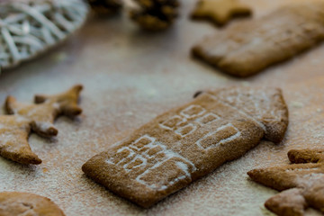 Gingerbread Christmas cookies, on a kitchen table, sprinkled with powdered sugar,  houses shapes. Concept Christmas and new sweet home, real estate.
