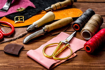 leather craft instruments on wooden background close up