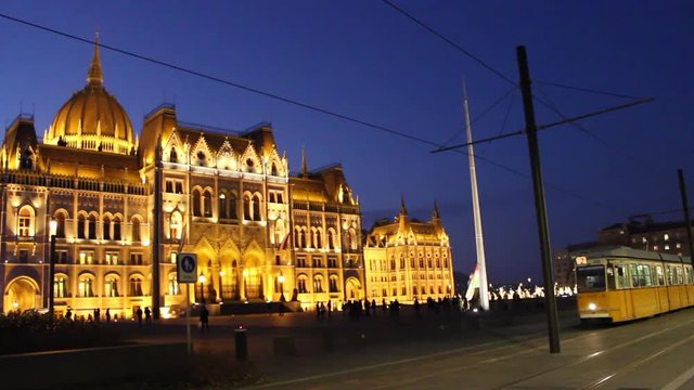 tram goes in front of parliament building in Budapest, Hungary at night