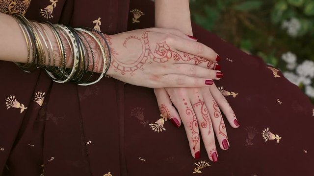 Close-up of Indian bride's hands covered with mehndi. Indian wedding ceremony. Mehendi hand. Mehndi covers Indian bride's hands with bracelets.