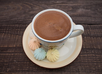 Cocoa with foam and bise on an old wooden table