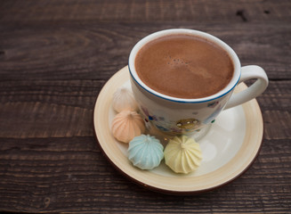Cocoa with foam and bise on an old wooden table