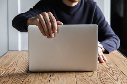 A man working on a laptop computer in the clean interior of a design country house in the netherlands.