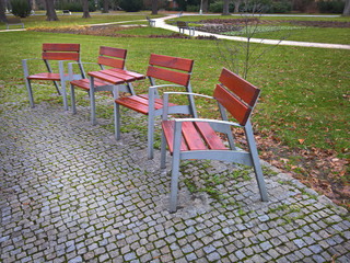 Fototapeta na wymiar Empty park banches and seats in November
