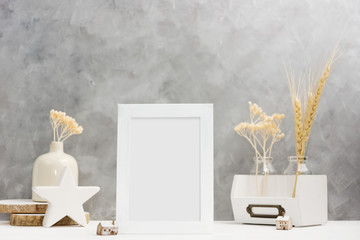 White Photo frame mock up with plants in vase with wooden and ceramic home decor on shelf. Scandinavian style. Text space