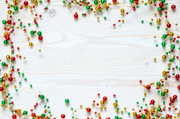 Fototapeta na wymiar Frame from a Christmas colorful garland on a white wooden surface. 
