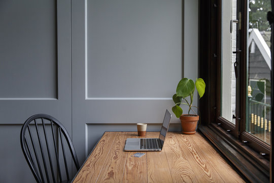 Laptop on wooden desk against window