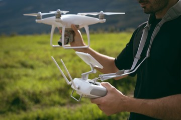 Man holding drone and remote control ready to take off