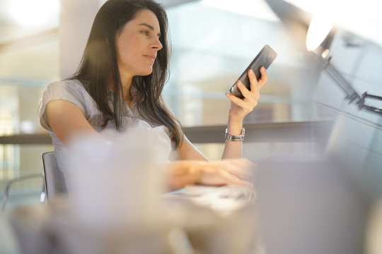 Businesswoman in office using smartphone