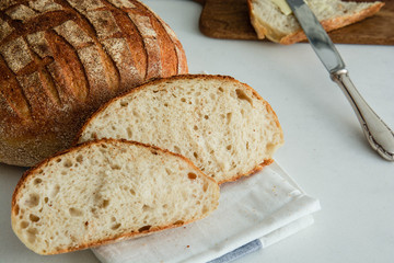 Homemade fresh bread sliced on a white background.