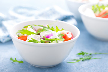 Fresh vegetable salad with feta cheese and olives in white bowl. Greek cuisine