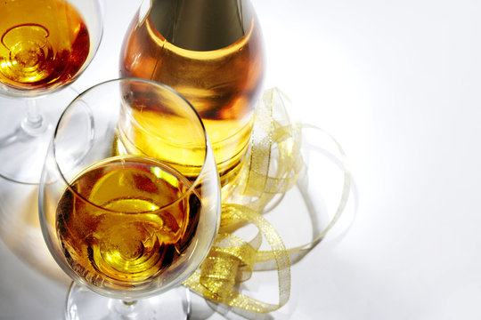 A bottle of champagne and a glass of wine ready to complete the celebration. Isolated on white background.