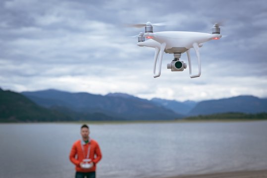 Man flying drone through remote control