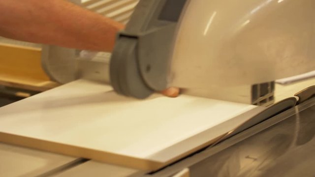 carpenter with panel saw and fibreboard at factory