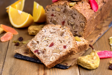 Slice of Homemade Tasty Fruit Cake Cake with Dried Fruit and Nuts Wooden Background