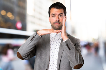 Handsome man making time out gesture on unfocused background