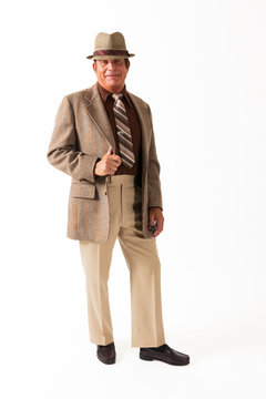 Older Man in Brown Suit with Hat on White Background. An older gentleman in a fine, brown suit with hat in front of a plain, white background.