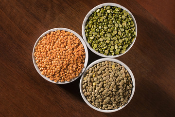 Various types of lentils (turkish, green and indian lentils) on wood background