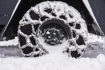 Snowy Chained wheel of a snow plow