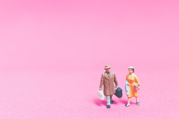 Miniature people : Couple of travellers on pink background&nbsp;, Valentine's day concept