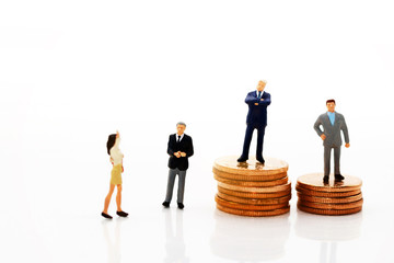 Miniature business people standing on step of coin money. Finance, investment and growth in business concept.