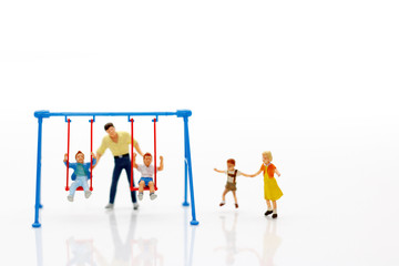 Miniature people, children and family enjoy with swing , happy family day concept.