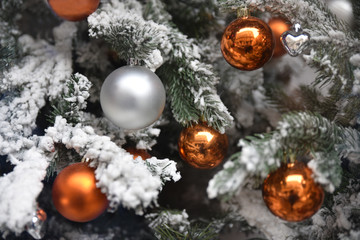 Obraz na płótnie Canvas Boules de Noël argent et cuivre dans sapin enneigé blanc