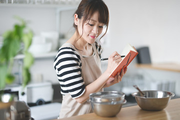 Obraz na płótnie Canvas 料理する女性・キッチン