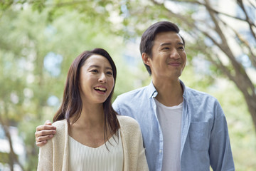 Fototapeta premium portrait of young Chinese couple standing & smiling outdoor