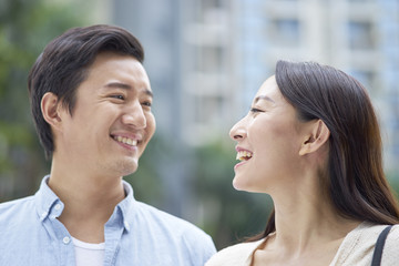 Naklejka premium portrait of young Chinese couple standing & smiling outdoor in garden