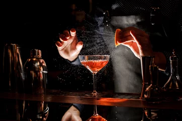 Crédence de cuisine en verre imprimé Cocktail Barman saupoudrant le jus d& 39 orange dans le cocktail