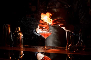 Crédence de cuisine en verre imprimé Cocktail Barman making a fresh cocktail with a smoky note