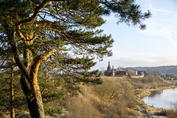 Evening landscape with trees, temple and river. The setting sun gives a beautiful light