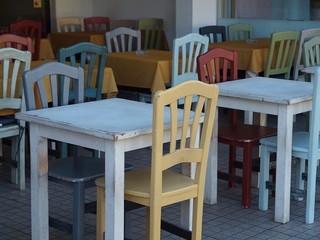 Bunte Tische und Stuehle in einem Cafe