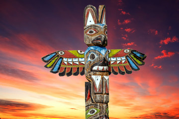 Totem wood pole in the gold cloudy background