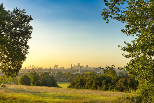 The City of London Cityscape at Sunrise with early Morning Mist from Hampstead Heath. Buildings include the Shard, Gherkin 30 St Mary Axe, St Pauls, Lloyds Building, Stock Exchange and Walkie Talkie.