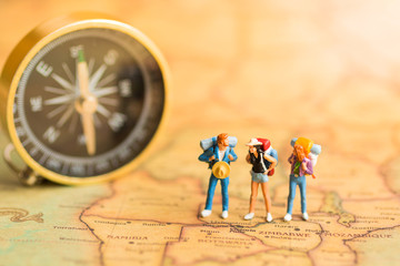 Miniature people : Travelers stand on the map world, walking to destination. Use as a business travel concept.