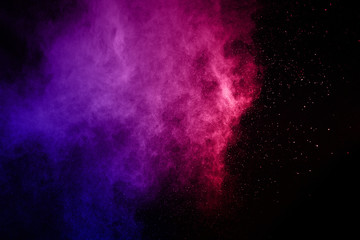abstract powder splatted background. Colorful powder explosion on black background. Colored cloud....