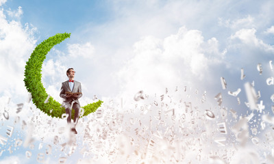 Young businessman or student studying the science and symbols fly around