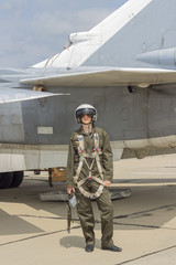Military pilot in helmet stands near jet plane © Arrows