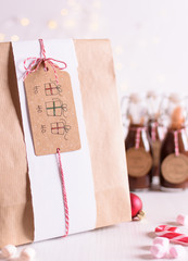 Chocolate liquor in little glass bottles. Idea for Christmas drinks, homemade and wrapped with christmas decorations. Christmas lights in the background.